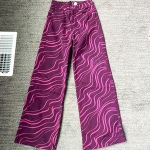 These are H and M straight jeans. They are dark purple with pink swirly designs.
